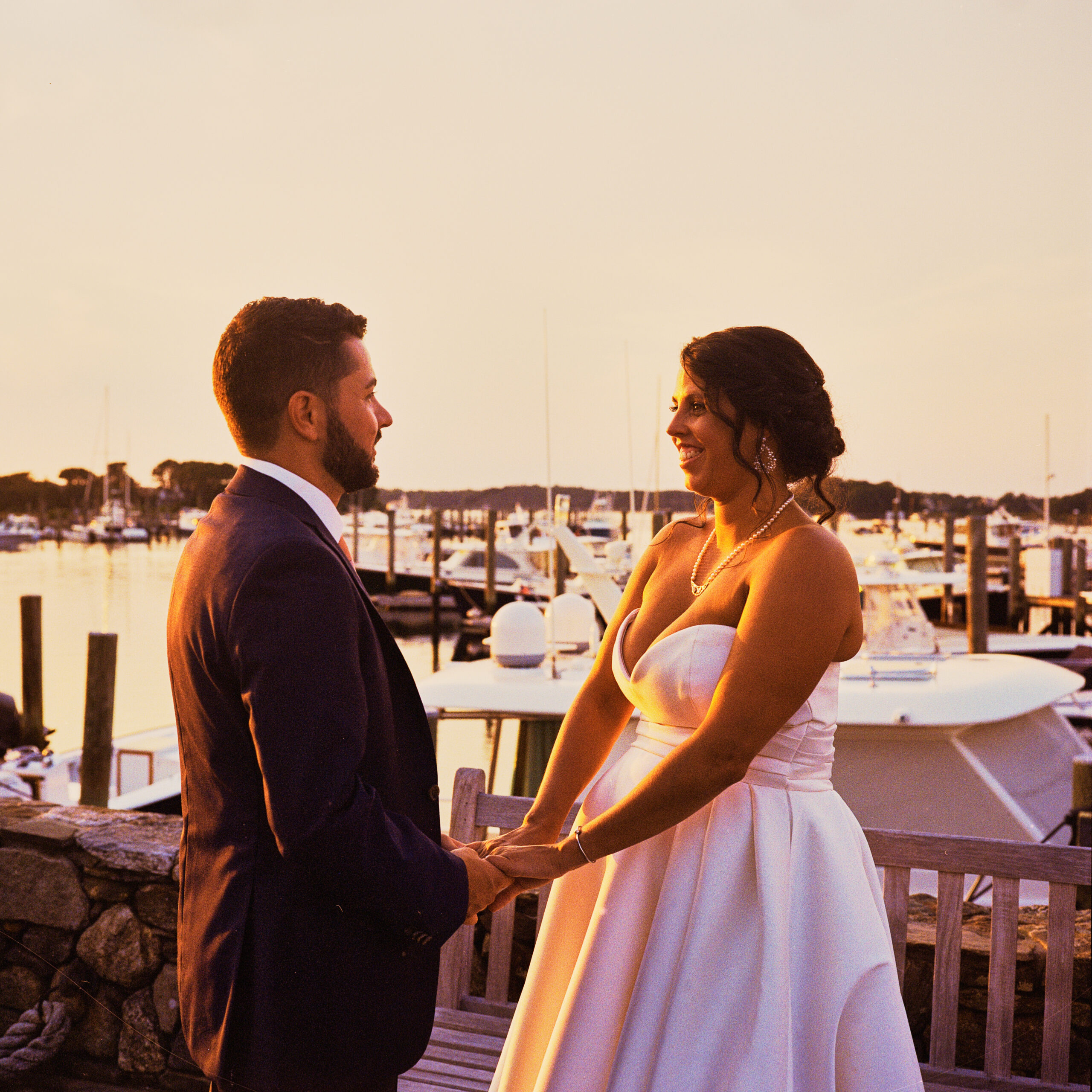 film photo of wedding couple in sunset holding hands posing